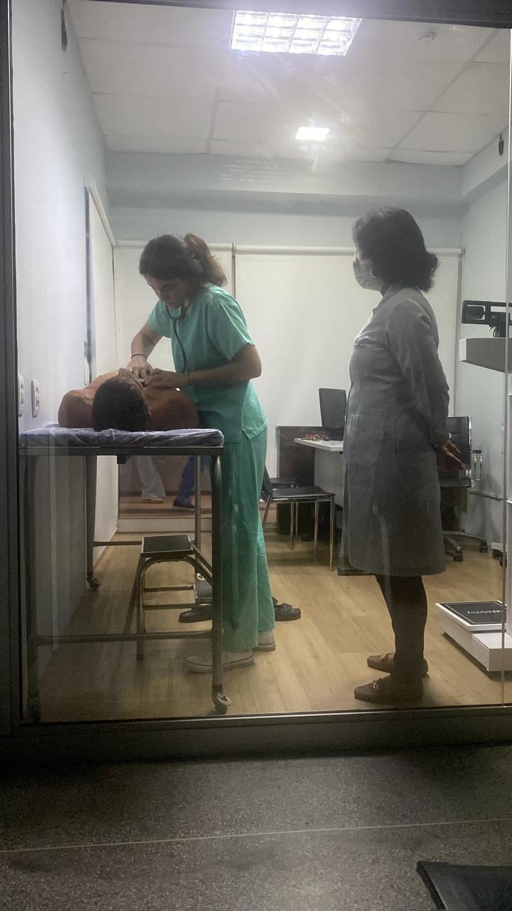 Professora acompanhando exame físico de estudante e estudante realizando exame físico na realidade virtual.